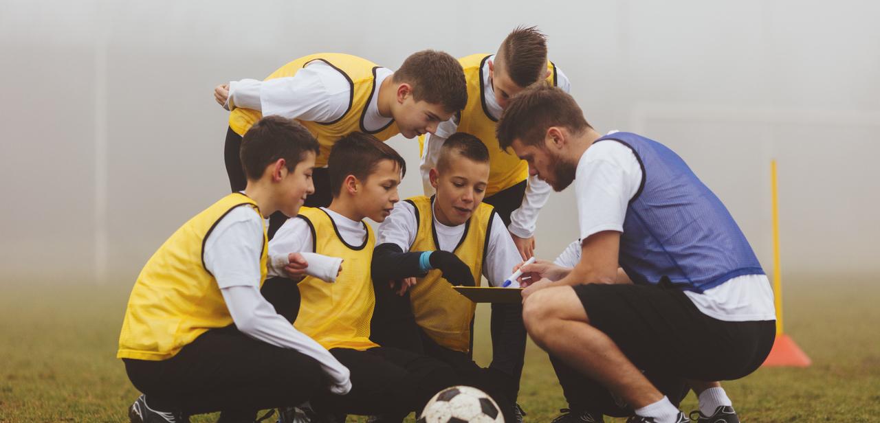Trainer mit Kids bei der Besprechung