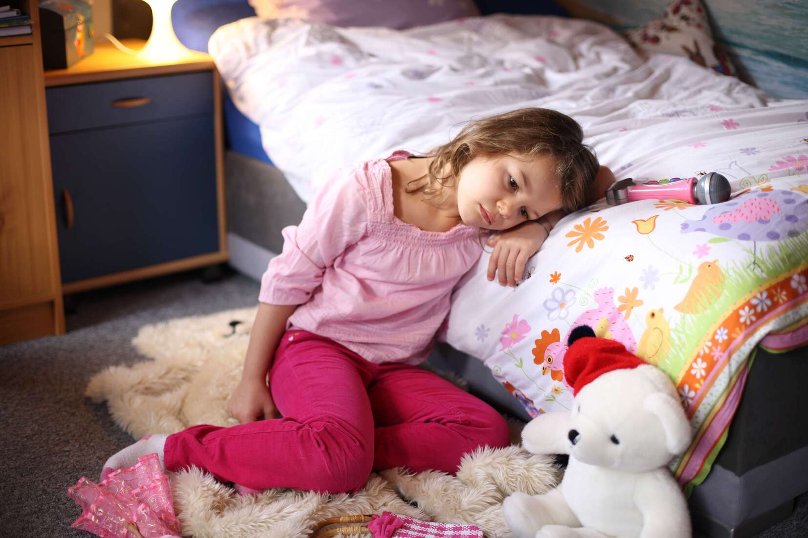 Trauriges Mädchen, das sich auf sein Bett lehnt
